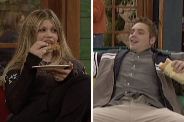 Danielle Fishel and Rider Strong are having a meal on a sitcom set. Danielle is holding a plate with food, while Rider is leaning back and laughing with a sandwich