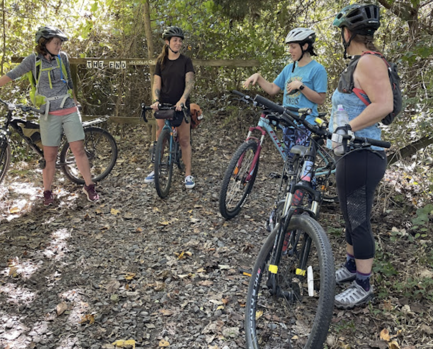 a group of women in the woods with bikes